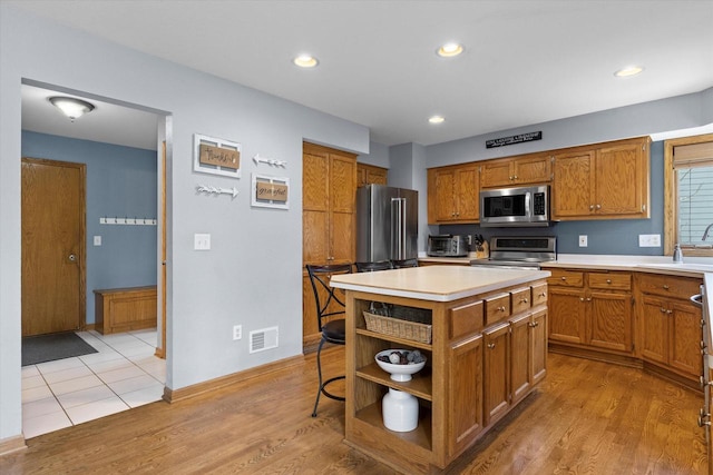 W127S9630 Scott Krause Dr, Muskego, WI 53150 - kitchen featuring appliances with stainless steel finishes, open shelves, a sink, light countertops, and brown cabinetry