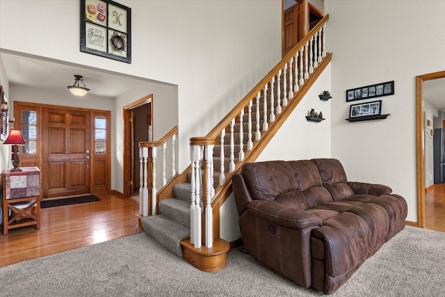 W127S9630 Scott Krause Dr, Muskego, WI 53150 - entryway featuring stairway, carpet, a high ceiling, wood finished floors, and baseboards