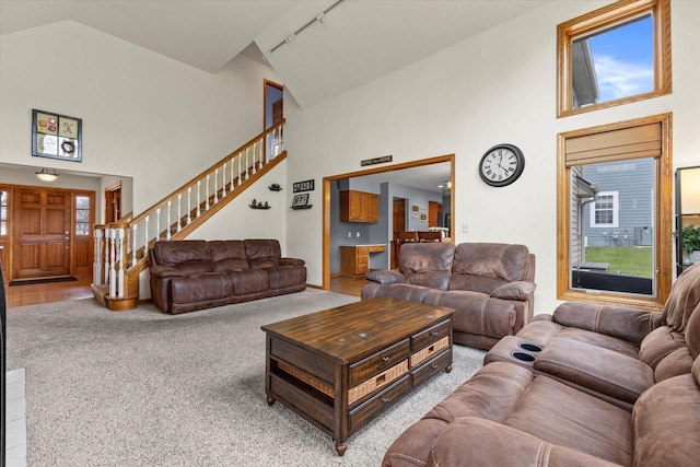 W127S9630 Scott Krause Dr, Muskego, WI 53150 - living room with high vaulted ceiling, rail lighting, carpet flooring, and stairs
