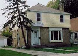 view of front of property with a chimney, a front lawn, and a garage