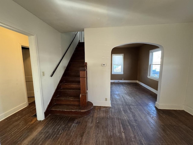 1306 W Wisconsin St, Portage, WI 53901 - stairway with hardwood / wood-style floors, arched walkways, and baseboards