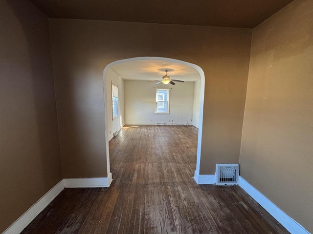 1306 W Wisconsin St, Portage, WI 53901 - hall featuring arched walkways, dark wood-type flooring, and baseboards
