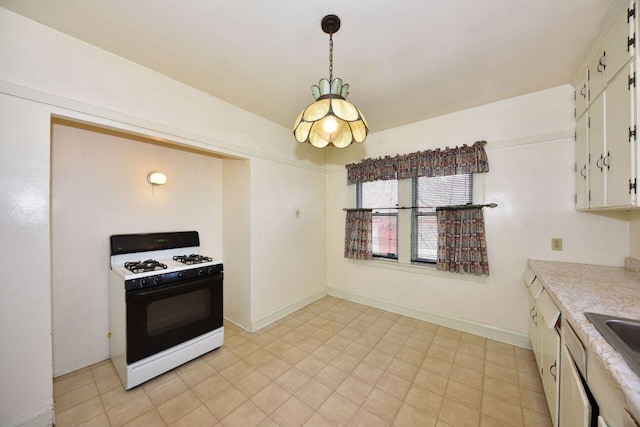 3434 N 45th St, Milwaukee, WI 53216 - kitchen featuring gas range, light countertops, white cabinets, pendant lighting, and baseboards