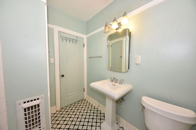3434 N 45th St, Milwaukee, WI 53216 - bathroom featuring tile patterned floors, toilet, a sink, and baseboards