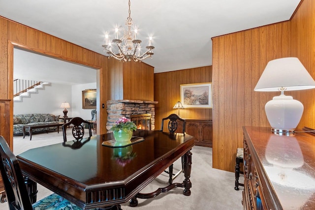 2289 Northwood Rd, Green Bay, WI 54313 - dining room featuring light carpet, wood walls, a chandelier, a fireplace, and stairway