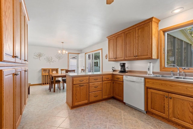 2289 Northwood Rd, Green Bay, WI 54313 - kitchen featuring dishwasher, a sink, a peninsula, a chandelier, and brown cabinetry