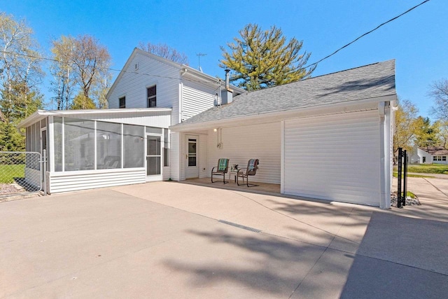 2289 Northwood Rd, Green Bay, WI 54313 - back of property with a sunroom, a shingled roof, fence, and a patio