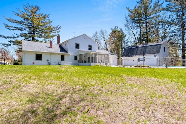 2289 Northwood Rd, Green Bay, WI 54313 - rear view of house featuring a sunroom, a chimney, and roof with shingles