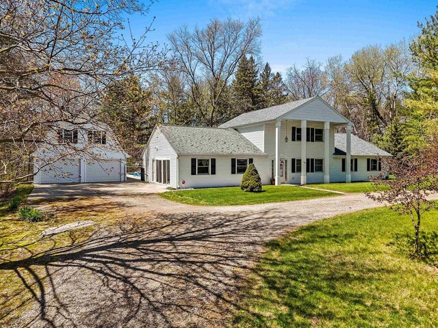 2289 Northwood Rd, Green Bay, WI 54313 - rear view of house featuring a yard, an outbuilding, roof with shingles, a garage, and driveway