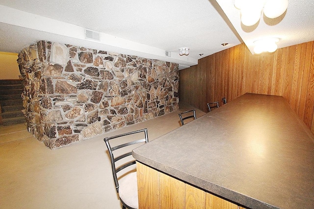 N3177 14th Dr, Montello, WI 53949 - unfurnished dining area with wood walls, stairs, and a textured ceiling