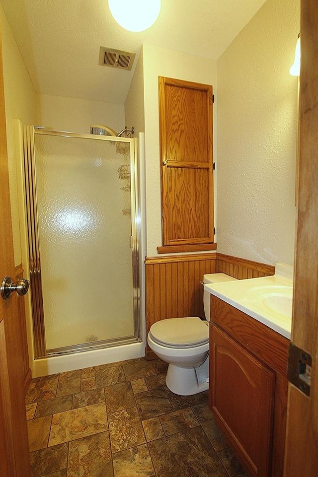 N3177 14th Dr, Montello, WI 53949 - full bath with a shower stall, stone finish floors, a wainscoted wall, vanity, and toilet