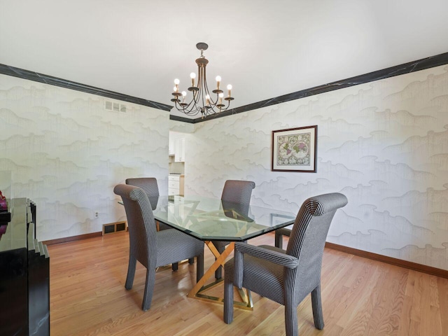 18585 Woodberry Ct, Brookfield, WI 53045 - dining space featuring a chandelier, light wood-style floors, baseboards, crown molding, and wallpapered walls