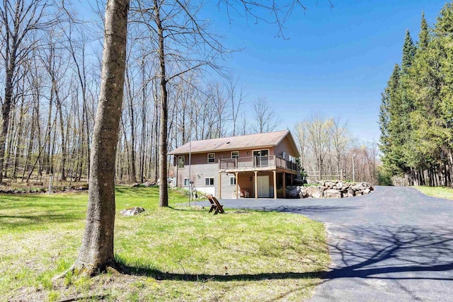 N11598 Helgeson Rd, Iola, WI 54945 - view of front of house with driveway, a deck, an attached garage, and a front yard
