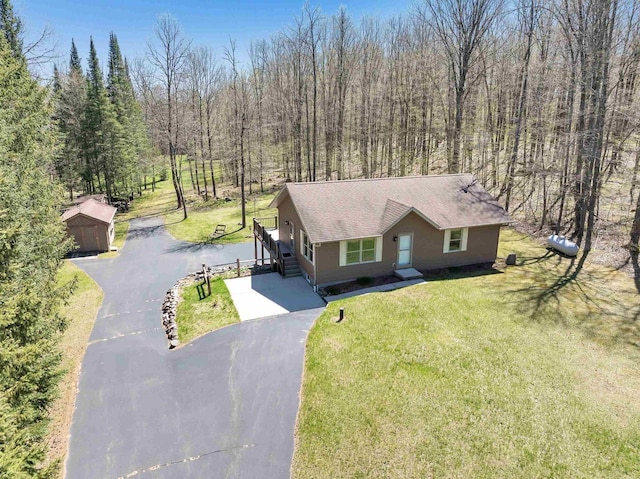 N11598 Helgeson Rd, Iola, WI 54945 - view of front of home featuring driveway, a front lawn, roof with shingles, and an outdoor structure