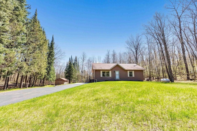 N11598 Helgeson Rd, Iola, WI 54945 - ranch-style home featuring a front yard, an outbuilding, and asphalt driveway
