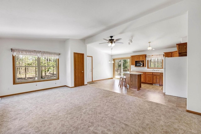 N11598 Helgeson Rd, Iola, WI 54945 - unfurnished living room featuring light colored carpet, lofted ceiling, ceiling fan, baseboards, and a sink