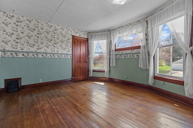 290 S Bridge St, Markesan, WI 53946 - empty room with wood-type flooring, wallpapered walls, a wainscoted wall, and baseboards