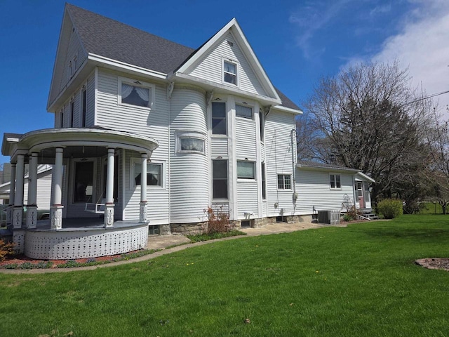 290 S Bridge St, Markesan, WI 53946 - back of house with covered porch, a yard, central air condition unit, and a shingled roof