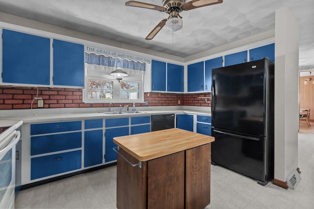 290 S Bridge St, Markesan, WI 53946 - kitchen featuring black appliances, blue cabinets, a sink, light flooring, and a ceiling fan