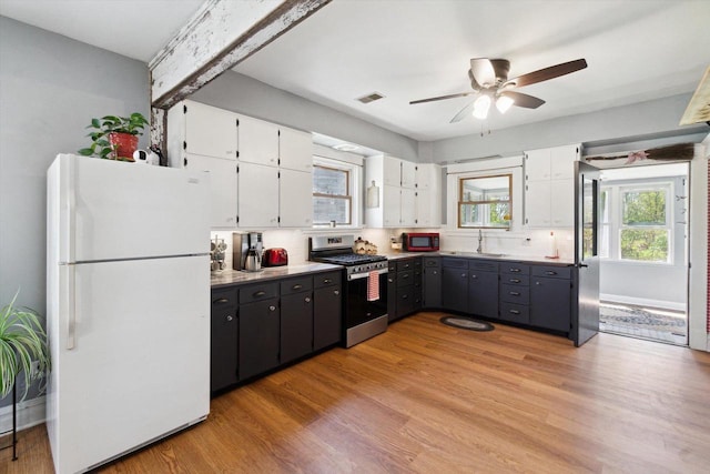 301 S Farmer St, Princeton, WI 54968 - kitchen with freestanding refrigerator, stainless steel range with gas cooktop, a sink, white cabinetry, and a ceiling fan