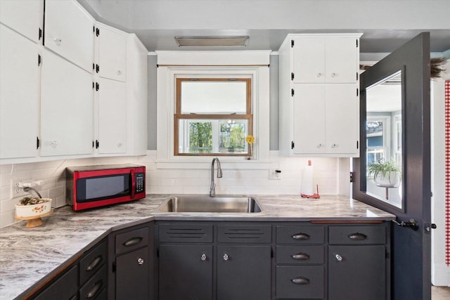 301 S Farmer St, Princeton, WI 54968 - kitchen featuring a sink, white cabinets, and tasteful backsplash