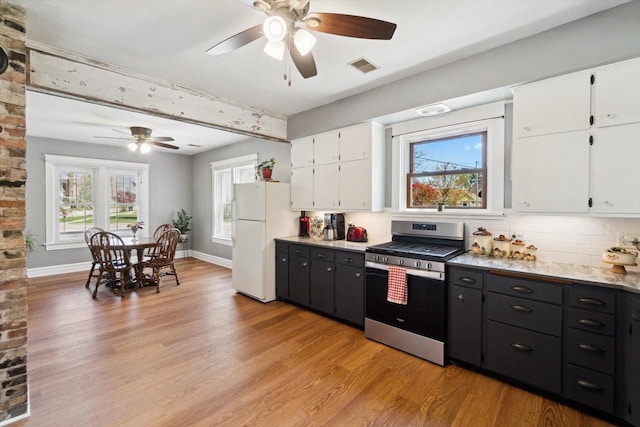 301 S Farmer St, Princeton, WI 54968 - kitchen featuring gas stove, freestanding refrigerator, ceiling fan, white cabinetry, and light wood-style floors