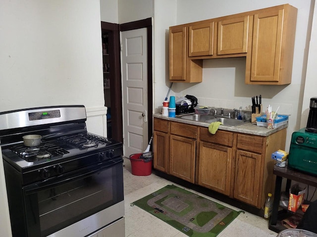 2931 N 2nd St Unit 2933, Milwaukee, WI 53212 - kitchen featuring stainless steel gas stove, a sink, light countertops, and brown cabinetry