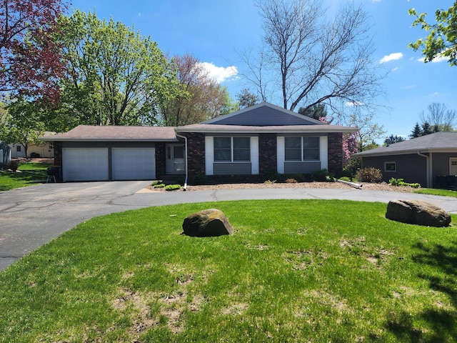 1120 W Blackhawk Dr, Fort Atkinson, WI 53538 - view of front of home with concrete driveway, an attached garage, and a front yard