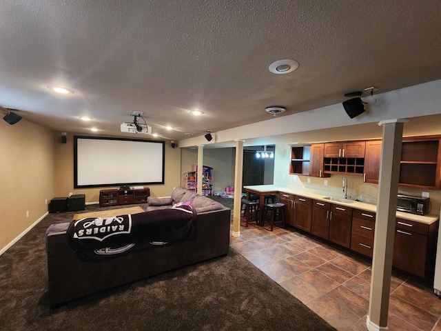 1120 W Blackhawk Dr, Fort Atkinson, WI 53538 - cinema room with bar with sink, a textured ceiling, and baseboards