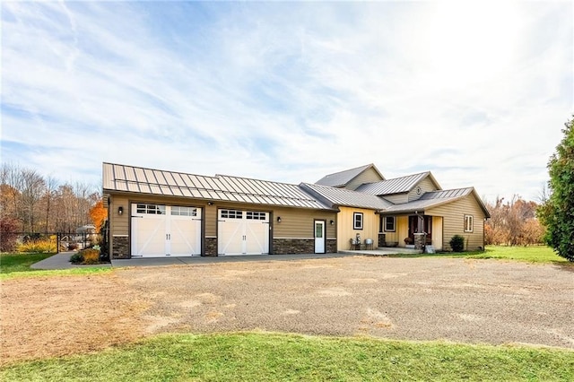 view of front of house featuring a standing seam roof, a garage, and metal roof