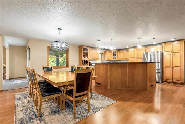 dining area featuring a textured ceiling and light wood-style floors