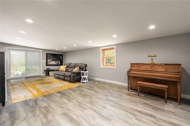 living area featuring baseboards, wood finished floors, and recessed lighting
