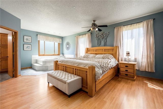 bedroom with a textured ceiling, light wood-style flooring, baseboards, and ceiling fan