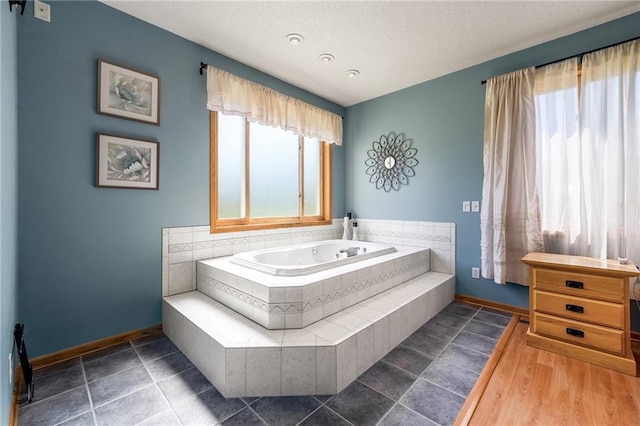 bathroom featuring baseboards, a garden tub, and a textured ceiling
