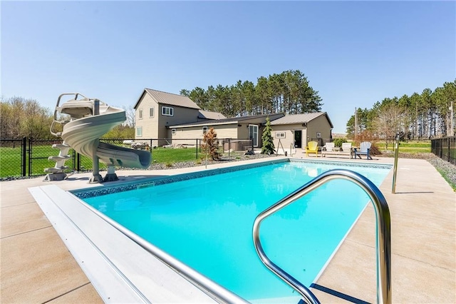view of pool with a water slide, fence, and a patio