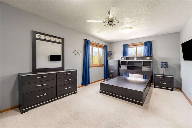 bedroom featuring baseboards, light carpet, a textured ceiling, and a ceiling fan