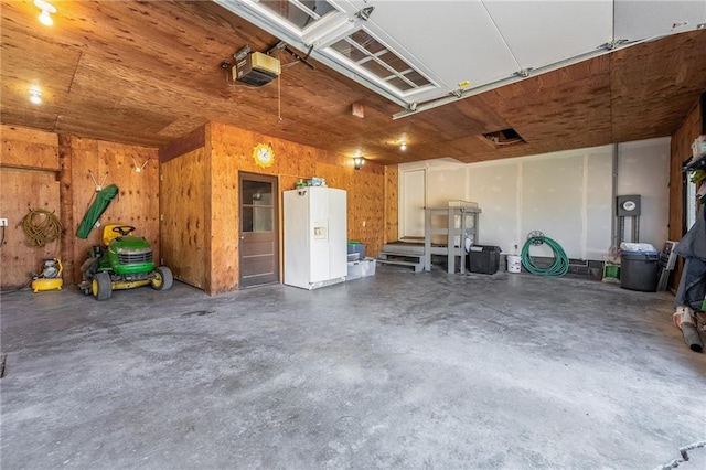 garage featuring wood walls and a garage door opener