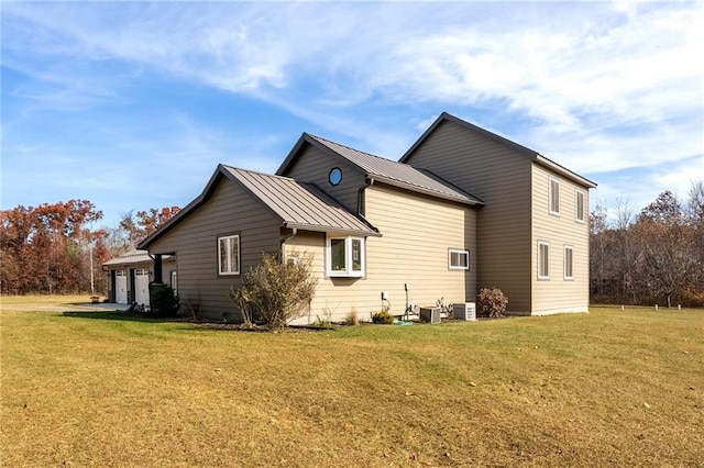 view of property exterior with a lawn, metal roof, a standing seam roof, and an attached garage
