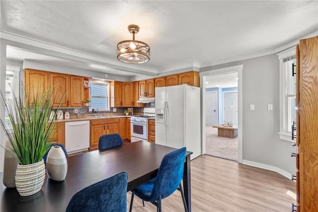 119 E 1st St, Dresser, WI 54009 - kitchen featuring white appliances, light wood-type flooring, under cabinet range hood, a sink, and brown cabinetry