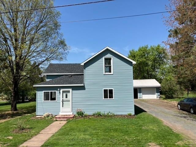 119 E 1st St, Dresser, WI 54009 - traditional-style home with roof with shingles, an outdoor structure, a front yard, and a garage