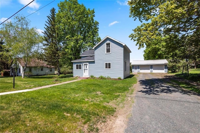 119 E 1st St, Dresser, WI 54009 - view of front of property featuring an outbuilding, a detached garage, entry steps, and a front yard