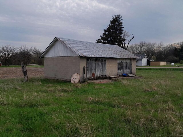 N2184 County Rd E, Redgranite, WI 54970 - view of home's exterior featuring concrete block siding, an outdoor structure, and metal roof