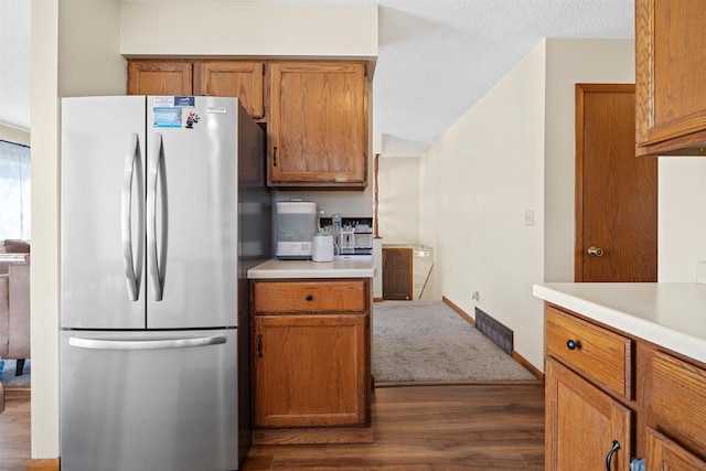 840 Waterworks Rd, Nekoosa, WI 54457 - kitchen with freestanding refrigerator, dark wood-style flooring, brown cabinets, and light countertops