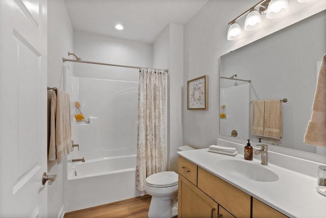 bathroom featuring toilet, wood finished floors, shower / bath combination with curtain, and vanity