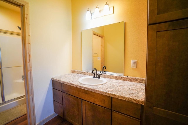 16845 Hawk Rd, Sparta, WI 54656 - full bathroom featuring a stall shower, vanity, and wood finished floors