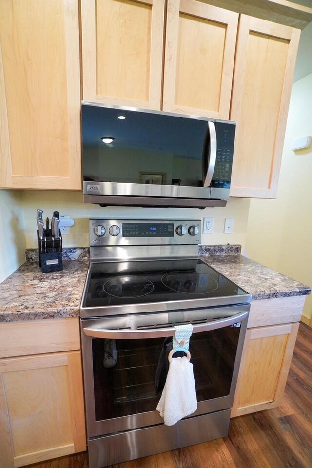 16845 Hawk Rd, Sparta, WI 54656 - kitchen featuring appliances with stainless steel finishes, light brown cabinets, dark wood finished floors, and stone countertops
