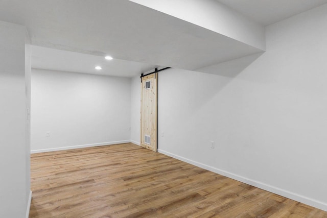 26 Prentice Pl, Madison, WI 53704 - below grade area with a barn door, recessed lighting, wood finished floors, and baseboards