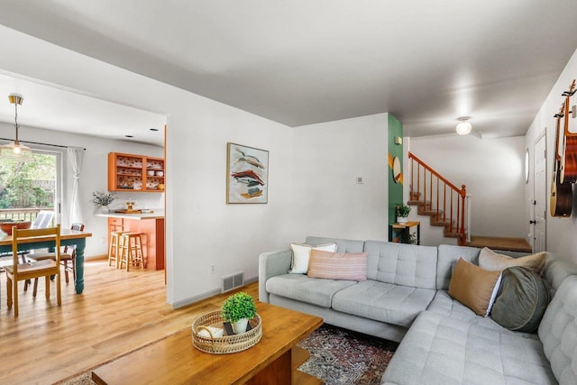 26 Prentice Pl, Madison, WI 53704 - living room featuring light wood-style floors, stairs, and baseboards