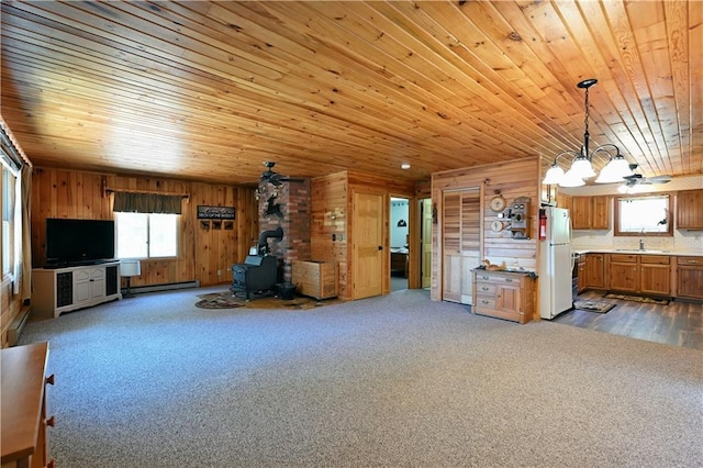 47025 Twin Pines Ln, Cable, WI 54821 - unfurnished living room with a wood stove, a sink, wooden ceiling, a chandelier, and wood walls