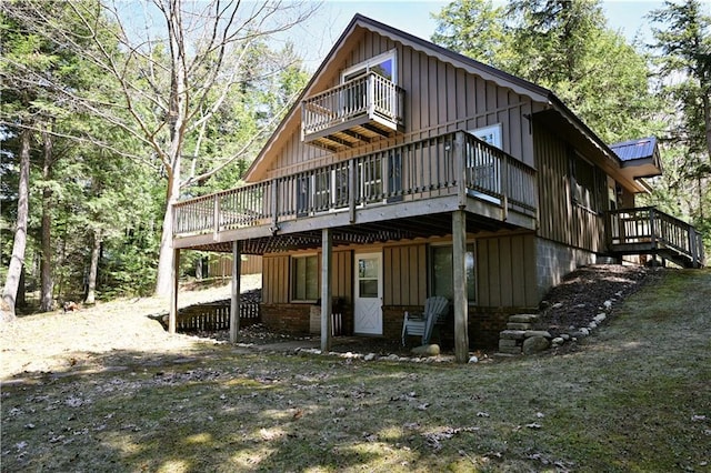 47025 Twin Pines Ln, Cable, WI 54821 - rear view of house with a balcony, board and batten siding, and a wooden deck